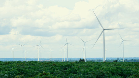 Progressive way of utilizing wind as renewable source of energy to power the modern way of life by wind turbine farm on green field or hill. Windmill generator generate electric with no CO2 emission.の写真素材