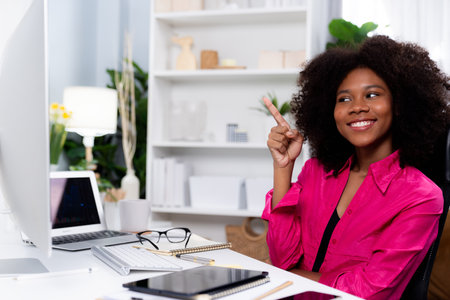 African woman smiling on happy face, looking on screen with valued achievement at high profit with newest company project. Concept of cheerful expression in work from home lifestyles. Tastemaker.の写真素材