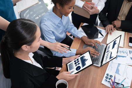 Multiracial analyst team use BI Fintech software to analyze financial data on meeting table. Financial dashboard data display on laptop screen with analyzed chart for marketing indication. Concordの写真素材