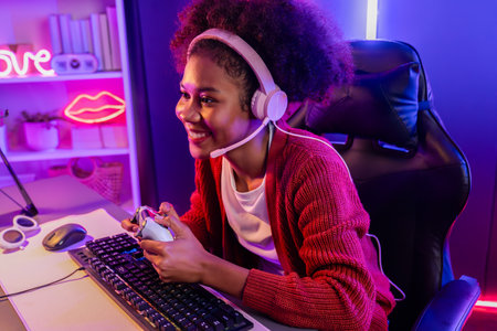 Host channel of gaming streamer, African girl wining with Esport skilled team player and viewers online game in neon color lighting room. Concept of cybersport indoor activities. Tastemaker.の写真素材