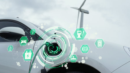Electric car recharging energy from EV charging station display futuristic smart battery status hologram by EV charger plug cable in wind turbine farm. Alternative clean energy sustainability. Peruseの写真素材
