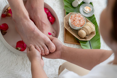 Woman indulges in blissful foot massage at luxurious spa salon while masseur give reflexology therapy in gentle day light ambiance resort or hotel foot spa. Quiescentの写真素材