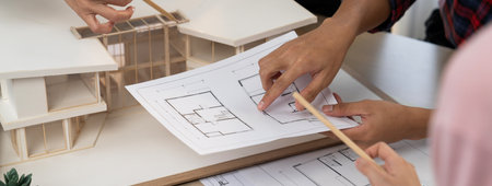 Architect team analysis and brainstorming about house construction at meeting table with house...