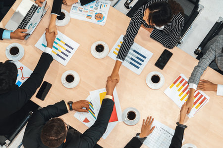 Group business people handshake at meeting table in office together with confident shot from top...