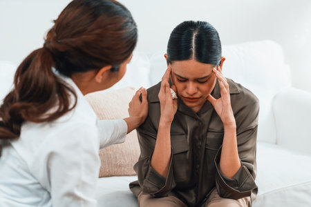 Sad PTSD woman patient in uttermost therapy for mental health with psychologist, depression or grief after life failure. Frustrated trauma young woman talking to a psychologist about emotion in clinicの写真素材