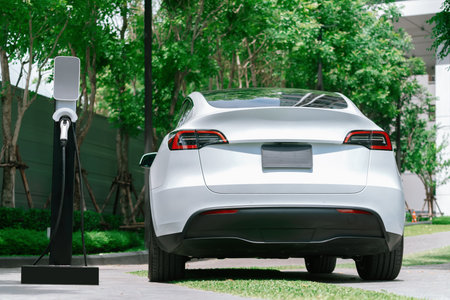 EV electric car charging in green sustainable city outdoor garden in summer. Urban sustainability lifestyle by green clean rechargeable energy of electric BEV vehicle innardsの写真素材