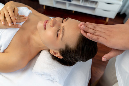 Caucasian woman enjoying relaxing anti-stress head massage and pampering facial beauty skin recreation leisure in dayspa modern light ambient at luxury resort or hotel spa salon. Quiescentの写真素材