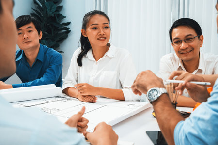 Diverse group of civil engineer and client working together on architectural project, reviewing...