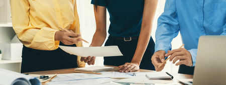 Architect team discuss about blueprint design at modern meeting room while her coworker working on...