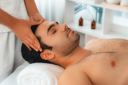Caucasian man enjoying relaxing anti-stress head massage and pampering facial beauty skin recreation leisure in dayspa modern light ambient at luxury resort or hotel spa salon. Quiescentの写真素材
