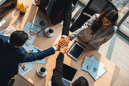 Happy business people celebrate teamwork success together with joy at office table shot from top view . Young businessman and businesswoman workers express cheerful victory show unity support . Jivyの写真素材
