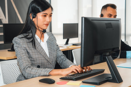 Business people wearing headset working in office to support remote customer or colleague. Call center, telemarketing, customer support agent provide service on telephone video conference call. Jivyの写真素材