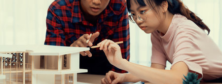 Smart architect engineer and interior designer working together and measuring house model by using...