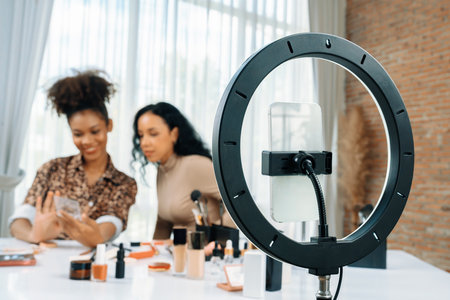 Woman influencer shoot live streaming vlog video review makeup crucial social media or blog. Happy young girl with cosmetics studio lighting for marketing recording session broadcasting online.の写真素材