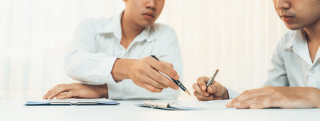 Business executive signing contract agreement document on the bale with the help from company attorney or lawyer service in law firm office. Business investing and finalizing legal processing. Shrewdの写真素材