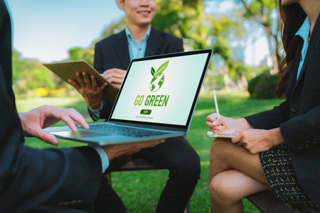 Group of asian business people planning on environmentally friendly development plan on laptop screen and sustainable technology project for greener future, outdoor eco office at natural park. Gyreの写真素材