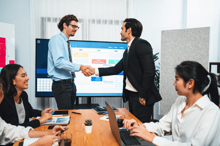 Cheerful meeting room, businesspeople celebrate with handshaking. Successful project was completed...