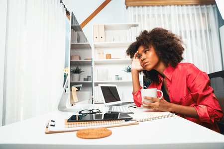 Young working African woman creating coding website developer, thinking data information designer at home office, focusing on laptop Concept of analytical data center in java project job. Tastemaker.の写真素材