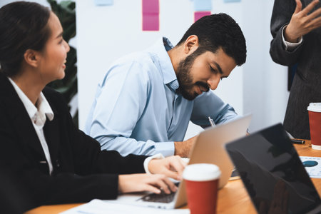 Professional Asian employee work together as team in corporate office, discussing business plans and data to achieve success on desk with laptop. Modern office worker teamwork concept. Concordの写真素材
