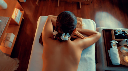 Top view woman customer enjoying relaxing anti-stress spa massage and pampering with beauty skin recreation leisure in warm candle lighting ambient salon spa at luxury resort or hotel. Quiescentの写真素材