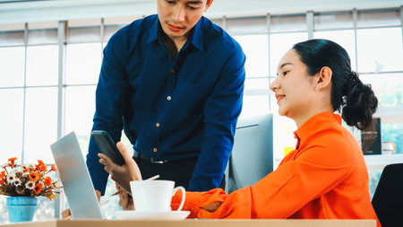 Two business people talk project strategy at office meeting room. Businessman discuss project planning with colleague at modern workplace while having conversation and advice on financial report. Jivyの写真素材
