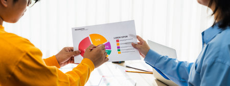 Startup company employee working together, analyzing BI dashboard paper on financial data report and...