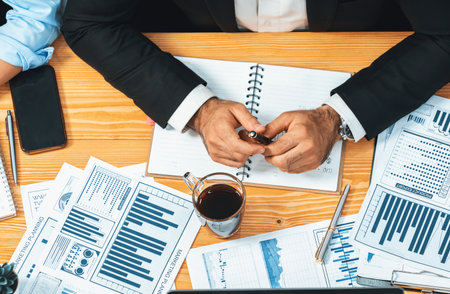 Top view diverse group of business analyst team analyzing financial data report paper on meeting table. Chart and graph dashboard by business intelligence analysis. Meticulousの写真素材