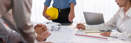 Engineer partner drawing and working on blueprint design together on office table for architectural...