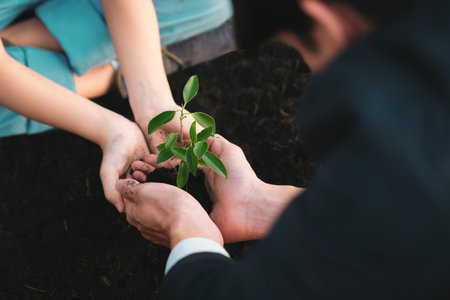 Businessman grow and nurture plant on fertilized soil with young boy as eco company committed to corporate social responsible, reduce CO2 emission and embrace ESG principle for sustainable future.Gyreの写真素材