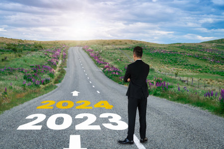 2024 New Year journey and future vision concept . Businessman traveling on highway road leading forward to happy new year celebration in beginning of 2024 for bliss and successful start .の写真素材