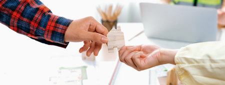 Professional engineer and architect collaborate on eco house project at meeting table with green design blueprint and architectural equipment at modern office. Focus on hand. Close up. Delineation.の写真素材