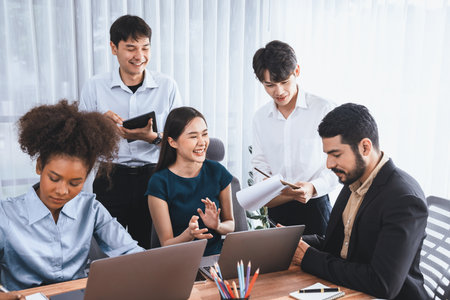 Happy diverse business people work together, discussing in corporate office. Professional and diversity teamwork discuss business plan on desk with laptop. Modern multicultural office worker. Concordの写真素材