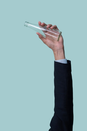 Businessmans hand holding glass bottle on isolated background. Eco-business recycle waste policy in corporate responsibility. Reuse, reduce and recycle for sustainability environment. Quaintの写真素材