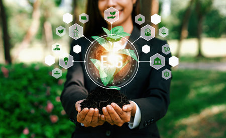 Focused young plant on soil with ESG and eco friendly icon design holding by blurred businesswoman symbolize environmental protection and natural preservation for greener future. Relianceの写真素材