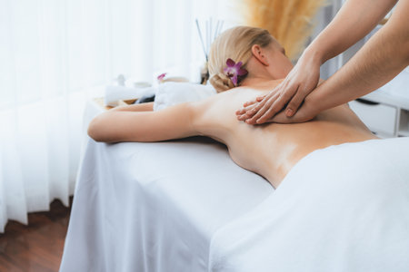 Caucasian woman customer enjoying relaxing anti-stress spa massage and pampering with beauty skin recreation leisure in day light ambient salon spa at luxury resort or hotel. Quiescentの写真素材