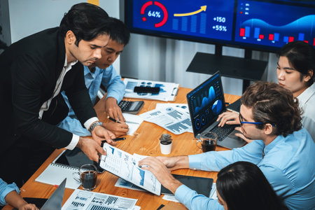 Wide top view of diverse group of business analyst team analyzing financial data report paper on meeting table. Chart and graph dashboard by business intelligence analysis. Meticulousの写真素材