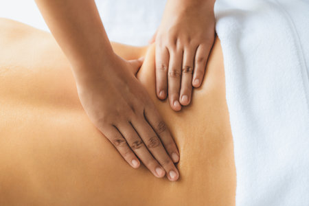 Closeup woman customer enjoying relaxing anti-stress spa massage and pampering with beauty skin recreation leisure in day light ambient salon spa at luxury resort or hotel. Quiescentの写真素材