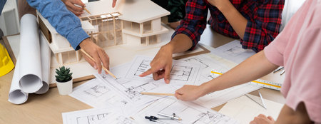 Skilled architect engineer team meeting pointing at blueprint while professional interior designer...