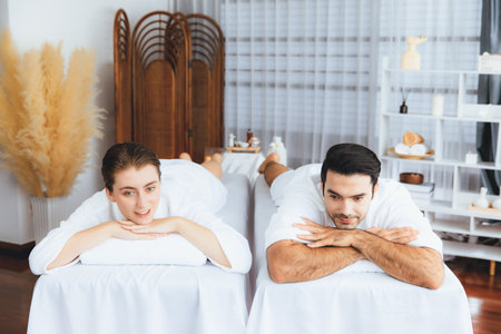 Caucasian couple customer enjoying relaxing anti-stress spa massage and pampering with beauty skin recreation leisure in day light ambient salon spa at luxury resort or hotel. Quiescentの写真素材