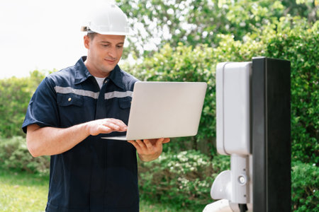 Qualified technician working on home EV charging station installation, making troubleshooting and...