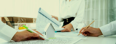 Worker, architect and engineer work on real estate construction project oratory planning with...