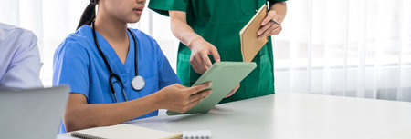Professional various team of medical working and planning medical treatment at hospital table...
