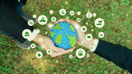 Two businessmens hand holding planet Earth together symbolize ESG business partnership commitment on environmental protection by using renewable energy for carbon reduction for greener Earth.Relianceの写真素材