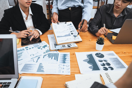 Multiracial analyst team use BI dashboard data to analyze financial report on meeting table. Group...