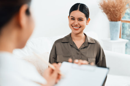 Happy patient and psychologist have mental health conversation in clinic with positive emotion while explaining uttermost successful work and life to psychologist in home office .の写真素材