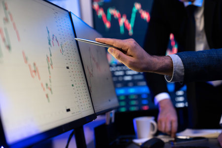 Stock traders pointing highest stock market on dynamic valued analysis on monitor real time screen,...