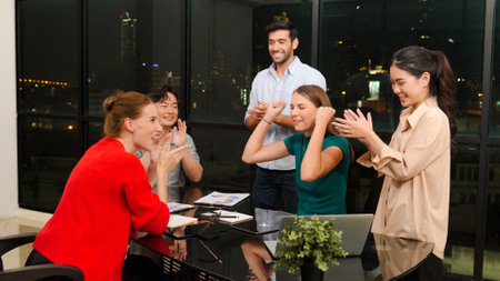 Businesspeople putting hands together and clapping hands to celebrate successful project at modern...