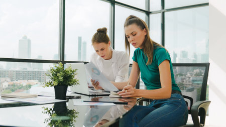 Skilled businesswoman look stress while discuss about financial strategy. Smart business team brainstorming, talking consulting sales plan, idea by using statistic document with tension. Traceryの写真素材