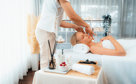 Caucasian woman enjoying relaxing anti-stress head massage and pampering facial beauty skin recreation leisure in dayspa modern light ambient at luxury resort or hotel spa salon. Quiescentの写真素材