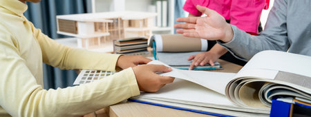 Skilled interior design team carefully selecting curtain materials while coworker selecting the...